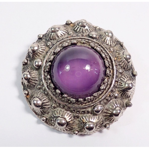 514 - A white metal circular brooch set cabochon purple stone, 4cm diameter