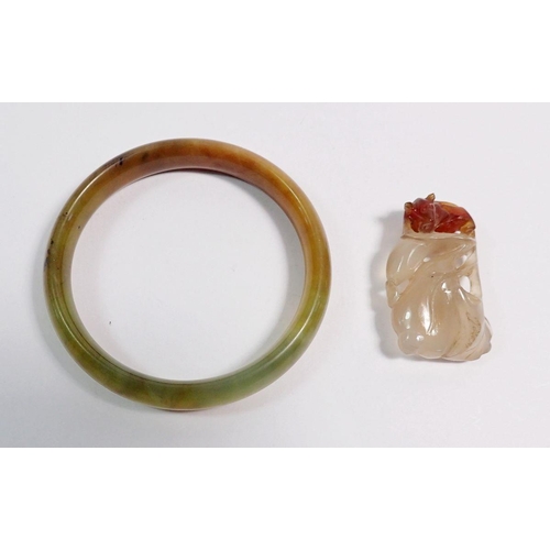 519 - A Chinese jade bangle, 7cm diameter and a jade pendant with carved rat on organic leaf decoration, 4... 