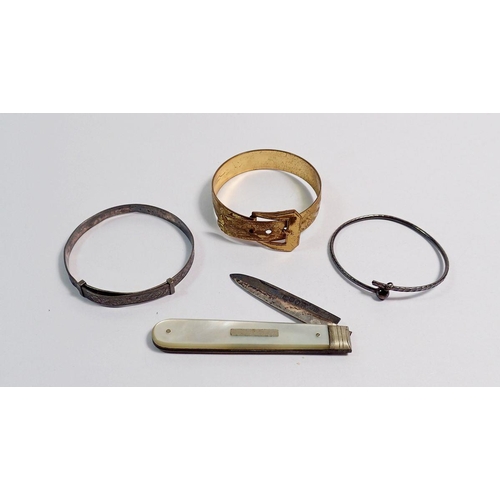 526 - A Victorian gilt metal bangle, a silver christening bangle, a silver and mother of pearl fruit knife... 