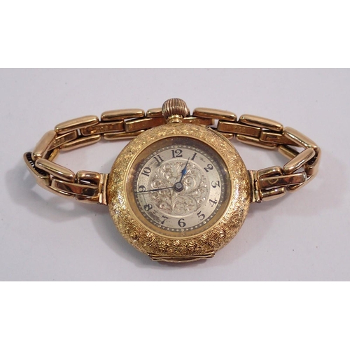 599 - An 18 carat gold early 20th century ladies wrist watch with all over engraved decoration, 3.2cm diam... 