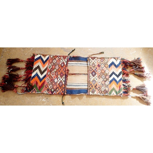 1288 - An antique camel saddle bag from Jordan, with geometric decoration and long tassels, 110 x 48cm plus... 