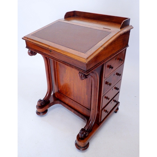 1306 - A Victorian walnut Davenport with slope top raised on scroll front supports and four drawers to side