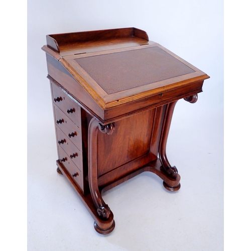 1306 - A Victorian walnut Davenport with slope top raised on scroll front supports and four drawers to side