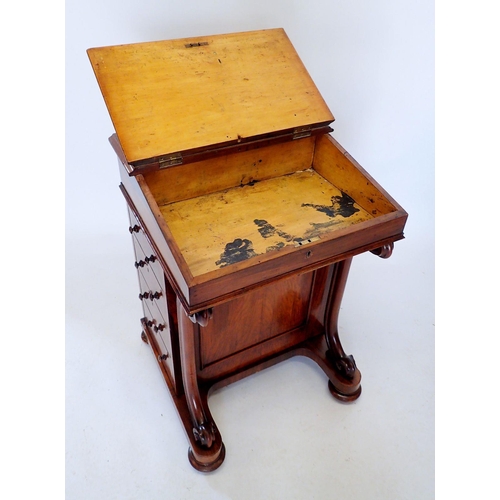 1306 - A Victorian walnut Davenport with slope top raised on scroll front supports and four drawers to side