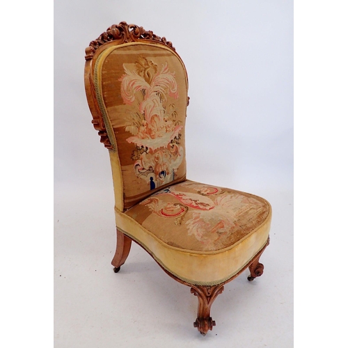 1308 - A Victorian nursing chair with finely carved scrollwork surmount and original petit point tapestry