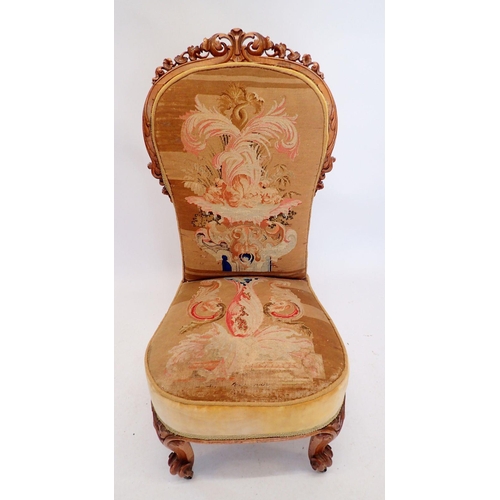 1308 - A Victorian nursing chair with finely carved scrollwork surmount and original petit point tapestry