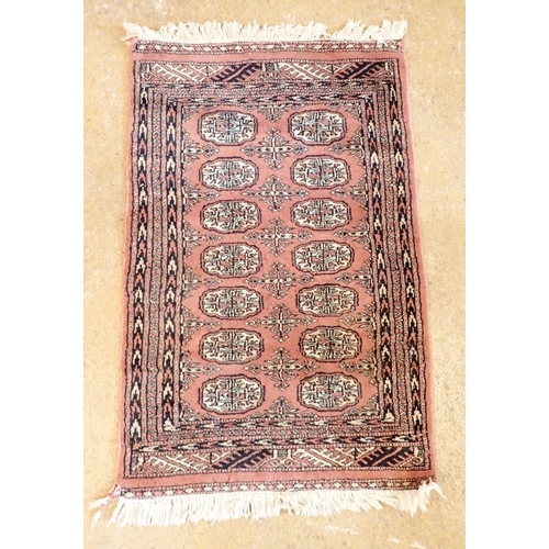 1317 - A small Turkoman style rug with fourteen guls on a pink ground, 98 x 63cm