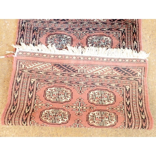 1317 - A small Turkoman style rug with fourteen guls on a pink ground, 98 x 63cm