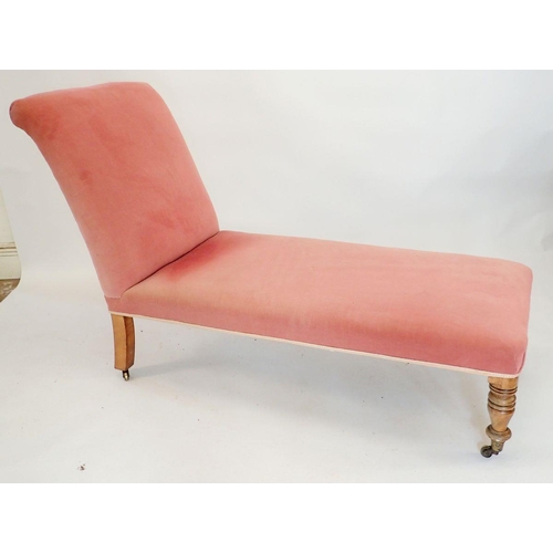 1332 - A Victorian pink chaise longue or day bed with scroll over end and turned supports, 120cm long