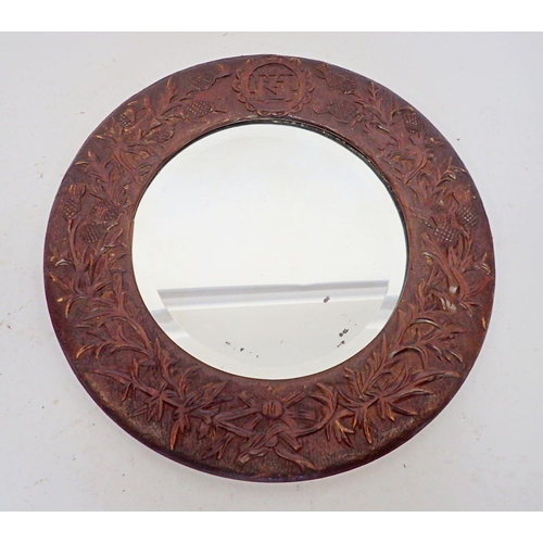 1337 - An Arts and Crafts carved wooden mirror with thistle decoration, 45.5cm diameter