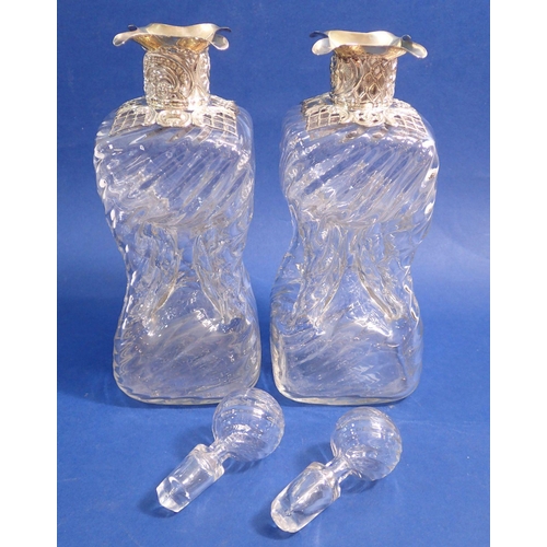 205 - A pair of Edwardian spiral moulded 'glug glug' glass decanters with silver mounts, 24cm wide,  Londo... 