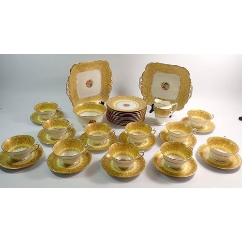 21 - A George Jones Crescent yellow and gold tea service comprising twelve plates, eleven cups and saucer... 