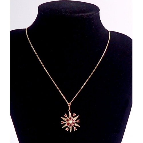 384 - A 9 carat gold star form pendant set rubies and seed pearls on 9 carat gold chain, pendant 2.5cm dia... 