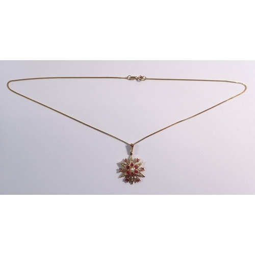 384 - A 9 carat gold star form pendant set rubies and seed pearls on 9 carat gold chain, pendant 2.5cm dia... 