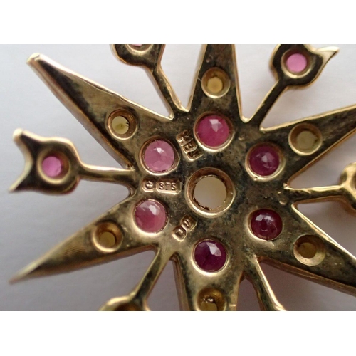 384 - A 9 carat gold star form pendant set rubies and seed pearls on 9 carat gold chain, pendant 2.5cm dia... 