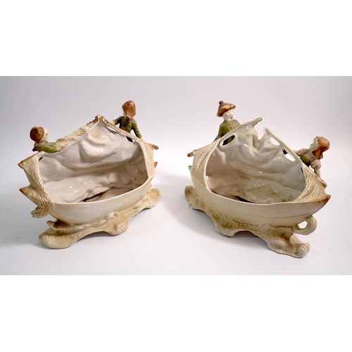 39 - A pair of 19th century continental bisque boat form vases with children and fishing nets, 22cm wide