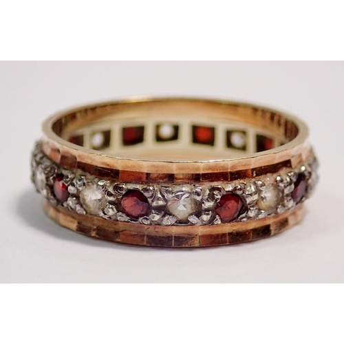 413 - A 9 carat gold eternity ring set garnets and white stones, size M to N, 3g