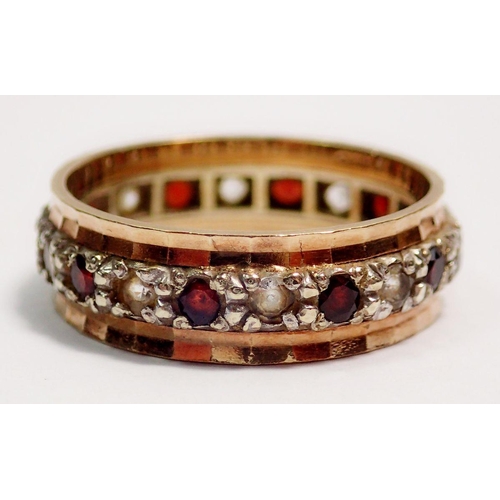 413 - A 9 carat gold eternity ring set garnets and white stones, size M to N, 3g