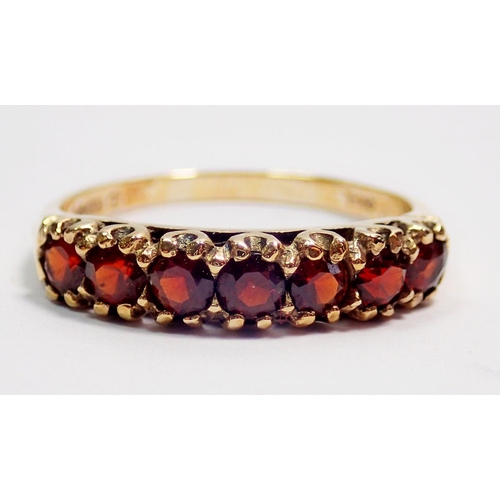 414 - A 9 carat gold ring set row of seven garnets, size Q, 2.3g