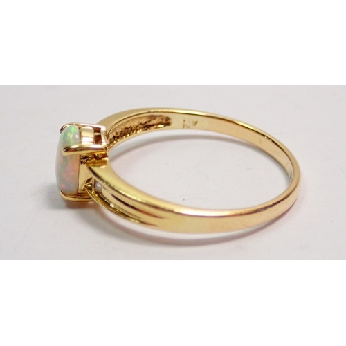 424 - An 18 carat gold opal ring inset two diamonds to redded barrel, size N to O, 2.5g