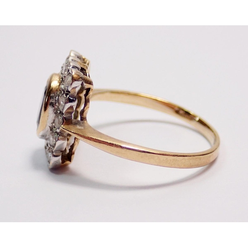 438 - An antique 9 carat gold ring, the oval cut sapphire within rectangular plaque set fourteen diamonds,... 