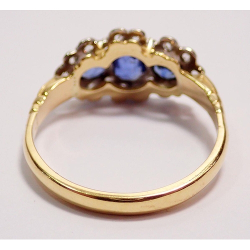 441 - An 18 carat gold ring set three sapphires within diamond surround, size K to L, 2.5g