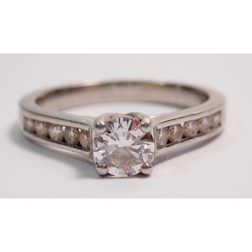 442 - A platinum ring set central diamond flanked by ten diamonds inset to shoulders, size M, 5.5g