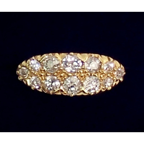 444 - An 18 carat gold ring set double row of twelve graduated diamonds, largest stones 4mm, size N, 5.3g