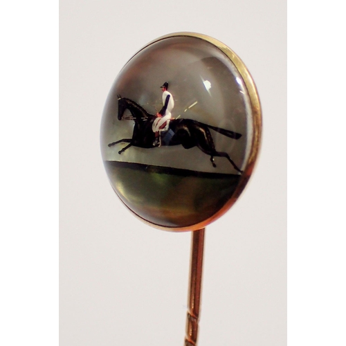 456 - An antique Essex crystal stick pin with jockey and race horse, set in 18 carat gold with original ca... 