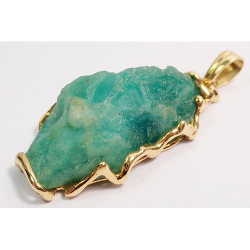 484 - A gold mounted uncut Columbian emerald pendant, 56.5k, 8.9g of gold, 6cm total length