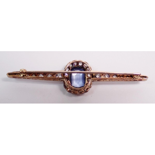 486 - A fine platinum and 15 carat gold bar brooch set central pale blue sapphire within sixteen stone dia... 