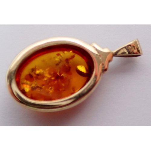 493 - An oval amber pendant in 9 carat gold surround, 2cm, 2.7g