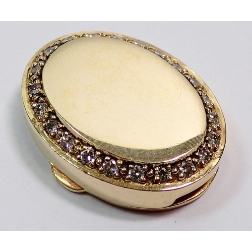 499 - A 9 carat gold oval pendant, the border set with diamonds, 2.1cm wide, 8.5g