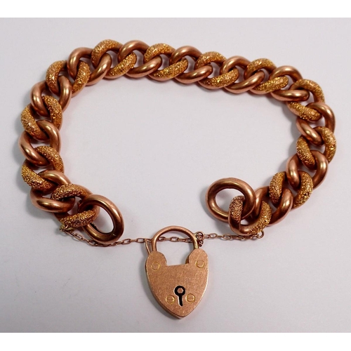 541 - A 9 carat rose gold curb link bracelet with heart lock and alternate engraved links, 24g