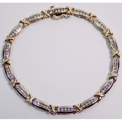 544 - A 9 carat yellow and white gold bracelet with fourteen links set seventy diamonds totaling one carat... 