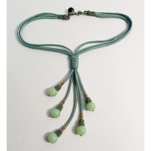 568 - A green silk multi strand necklace with five jade beads, boxed