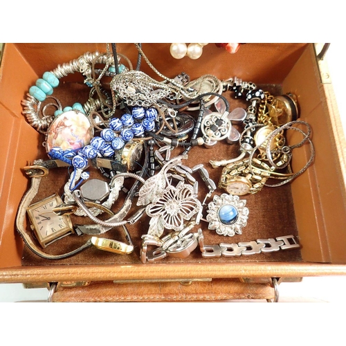 668 - A jewellery box containing various costume jewellery including earrings, brooches, watches etc.