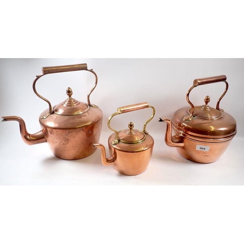 804 - Three various copper graduated kettles with lids and handles, largest 30cm high