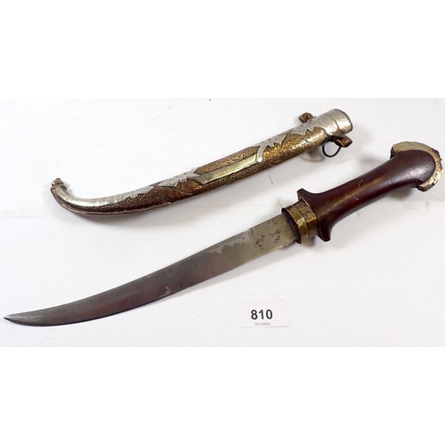 810 - An Eastern dagger with curved blade and decorative brass and white metal sheath, 40cm long