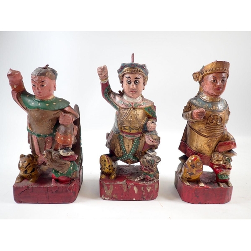 888 - A set of three Eastern polychrome carved wood figures of deitys with animals, 16cm