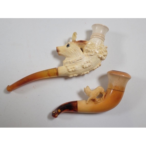 963 - Two amber and meerschaum cheroot holders, one a carved goat with glass horns and eyes, one with smal... 