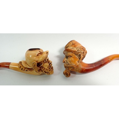 969 - Two amber and meerschaum cheroot holders, one with bearded man in animal head helmet, one in the for... 