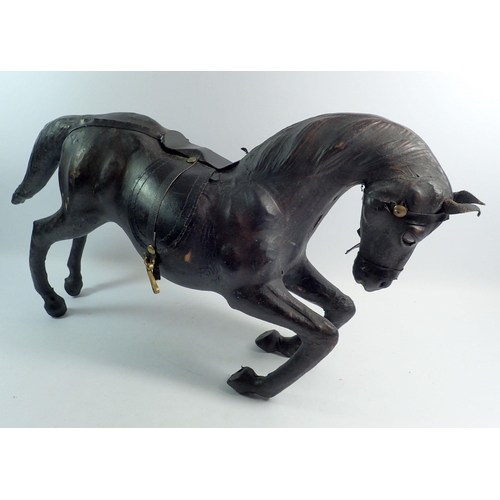 1113 - An early 20th century large leather covered bowing horse, 62cm long