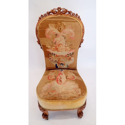 1117 - A Victorian nursing chair with finely carved scrollwork surmount and original petit point tapestry