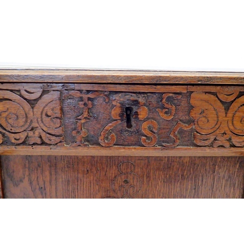 1132 - An 18th century oak coffer with carved lozenge decoration to triple panel front, 135cm wide