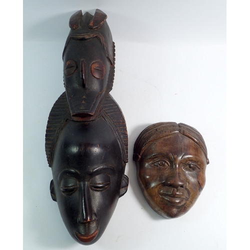 1142 - A carved double face mask made by the Baule tribe Ivory Coast together with another carved face from... 