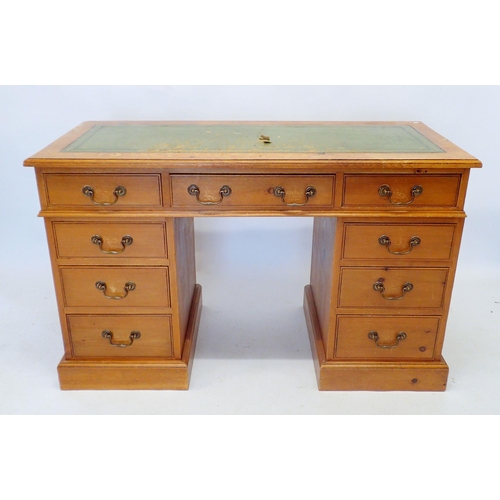 1144 - A stained pine twin pedestal desk with inset leather top and nine drawers, 126cm wide