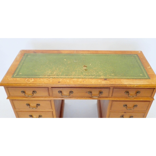 1144 - A stained pine twin pedestal desk with inset leather top and nine drawers, 126cm wide