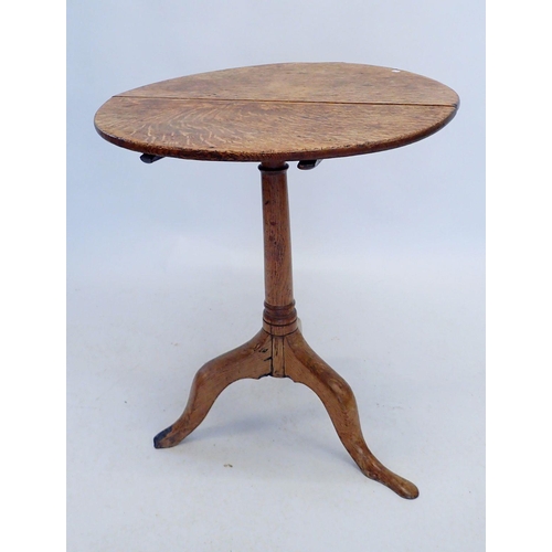 1145 - A Georgian oak tilt top occasional table on turned column and triple scroll supports (supports worn)... 