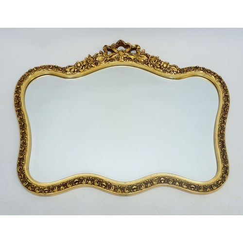 1311 - A vintage gilt framed mirror with ribbon and floral surmount, 87 x 72cm